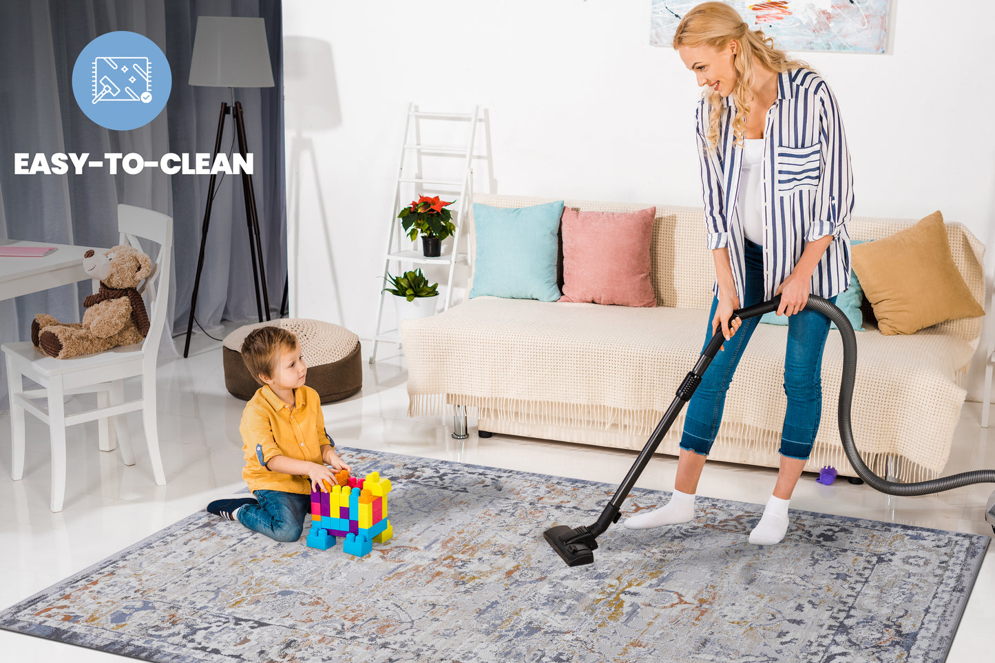 Grey abstract pattern area rug being vacuumed by a woman family friendly