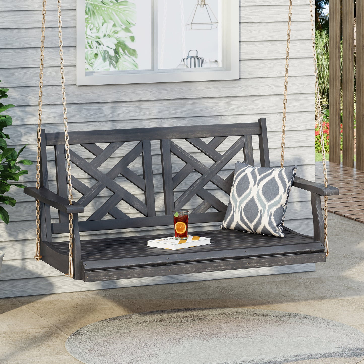 Dark gray wooden porch swing with ornate crisscross back design and gold chains