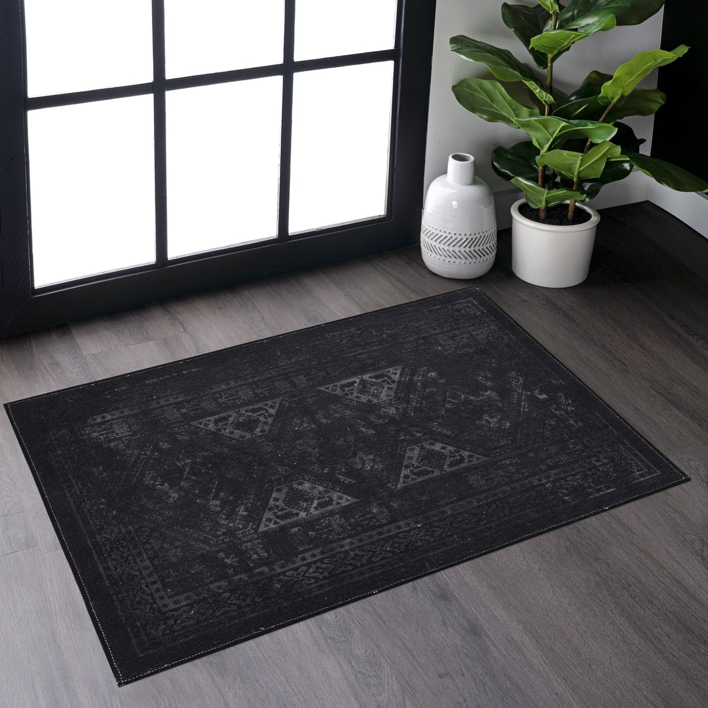 Distressed black Oriental rug with geometric pattern and faded finish for modern living rooms