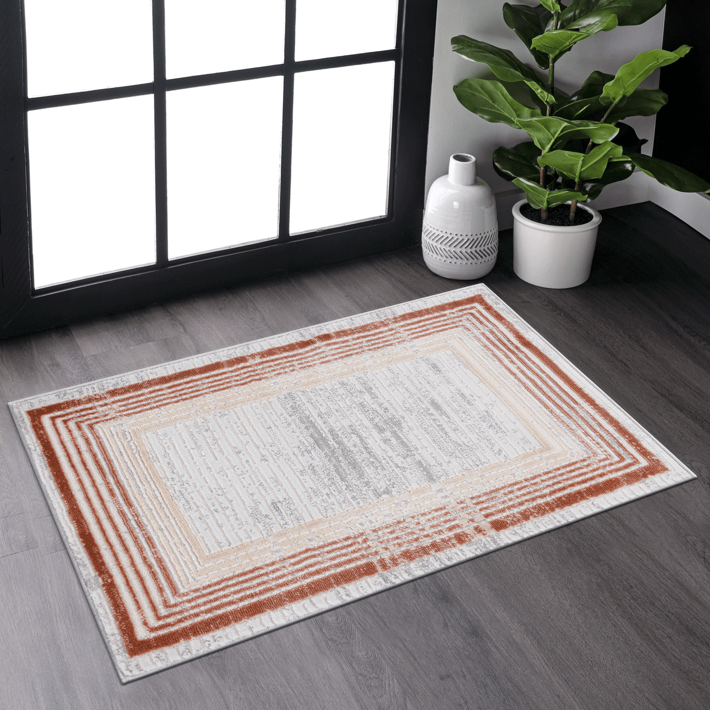 Rectangular area rug with concentric rectangle border in terracotta and beige on offwhite background