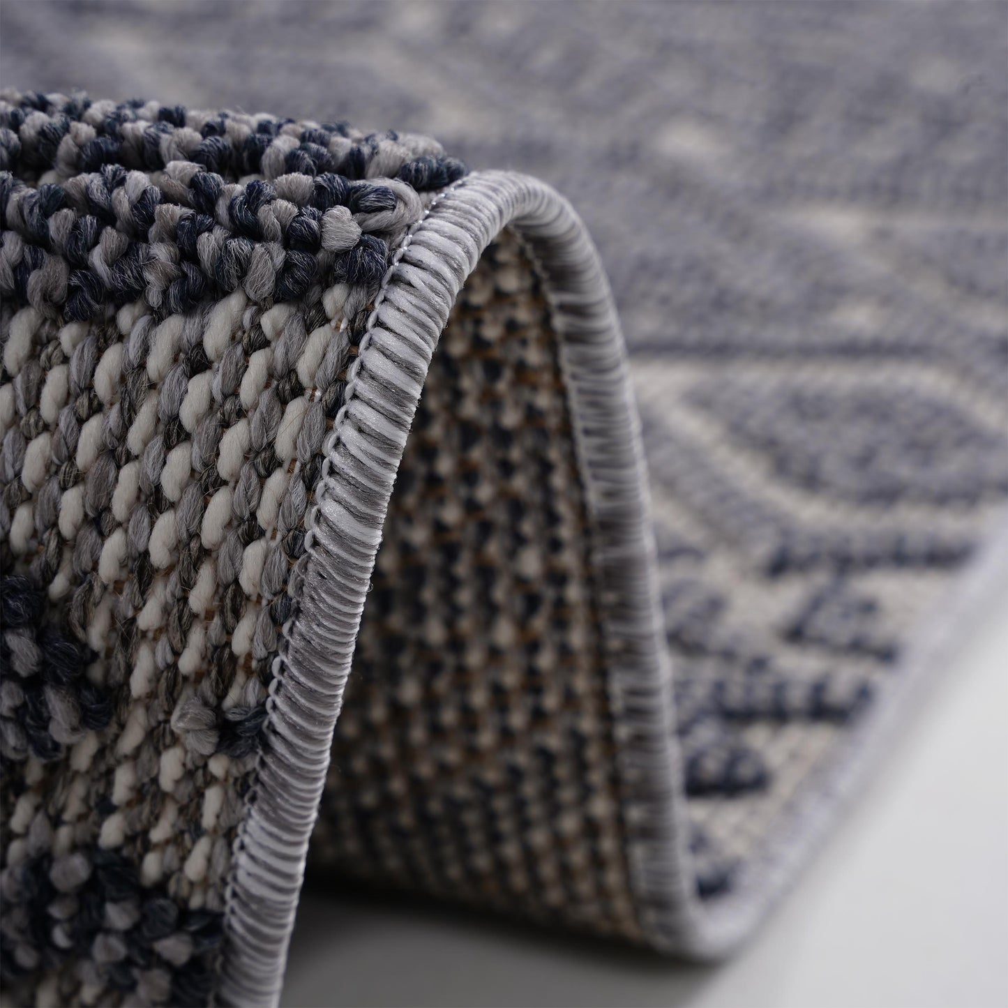 Closeup of a textured blue and grey geometric rug showcasing its plush weave