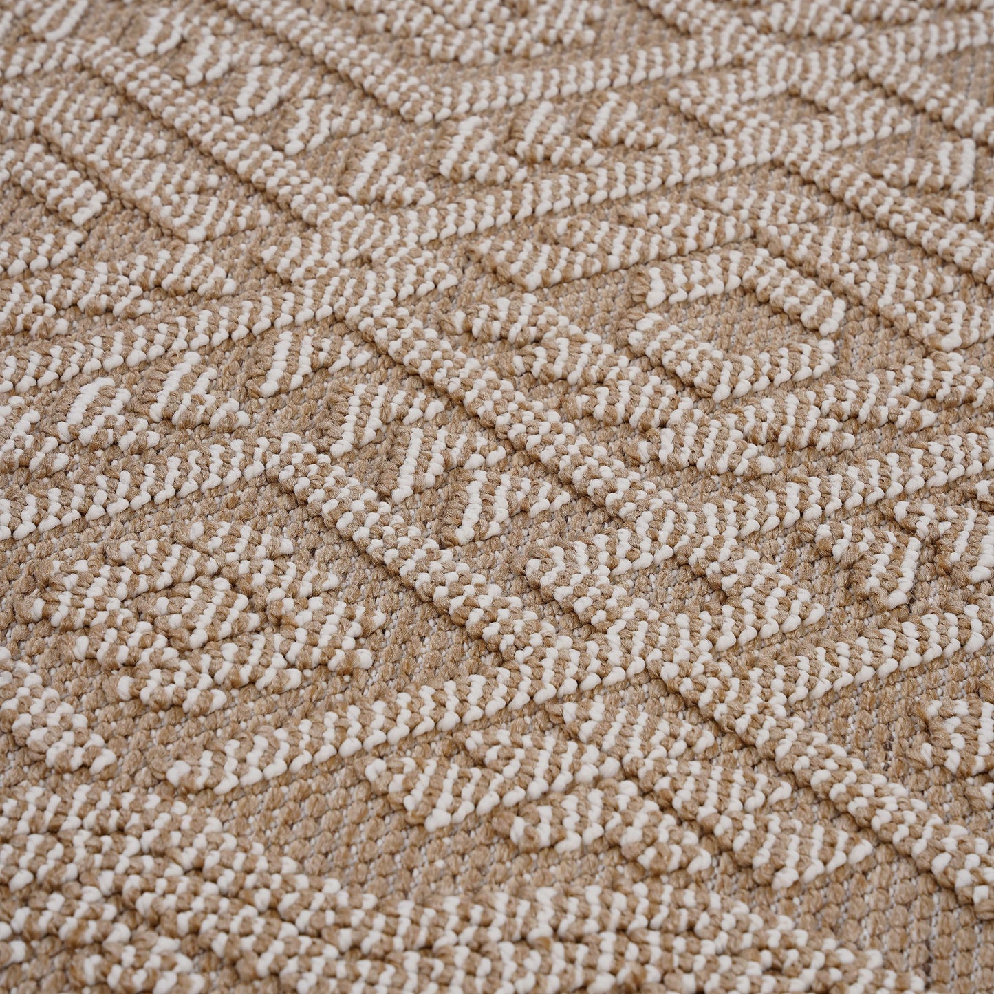 Closeup of a textured rug with a diamond pattern in beige and cream jute fabric