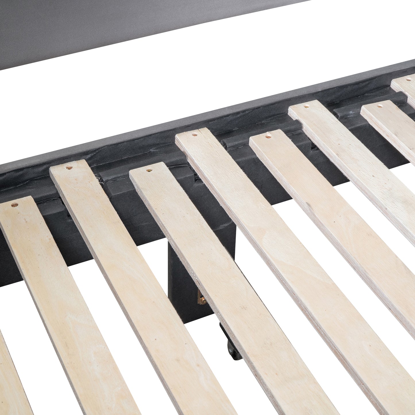 Closeup of a dark grey upholstered bed frame with natural wooden slats supporting the mattress