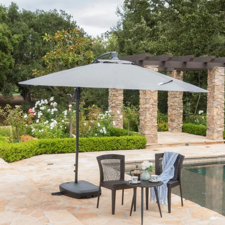 Gray rectangular cantilever patio umbrella with black base providing shade by a pool