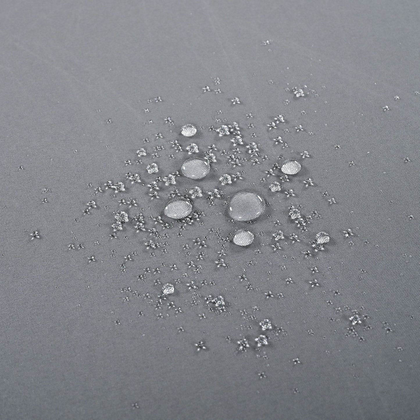 Closeup of water beads on a grey waterproof fabric texture