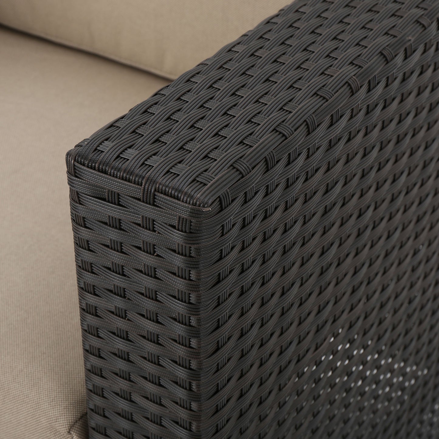 Dark brown wicker armrest detail with beige cushion fabric