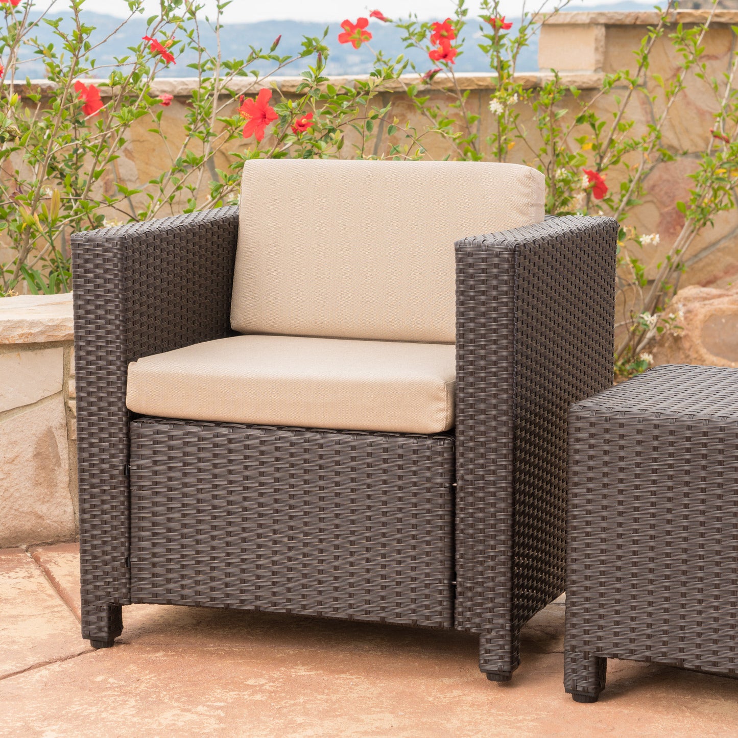 Dark brown rattan armchair with beige cushions perfect for outdoor patio seating