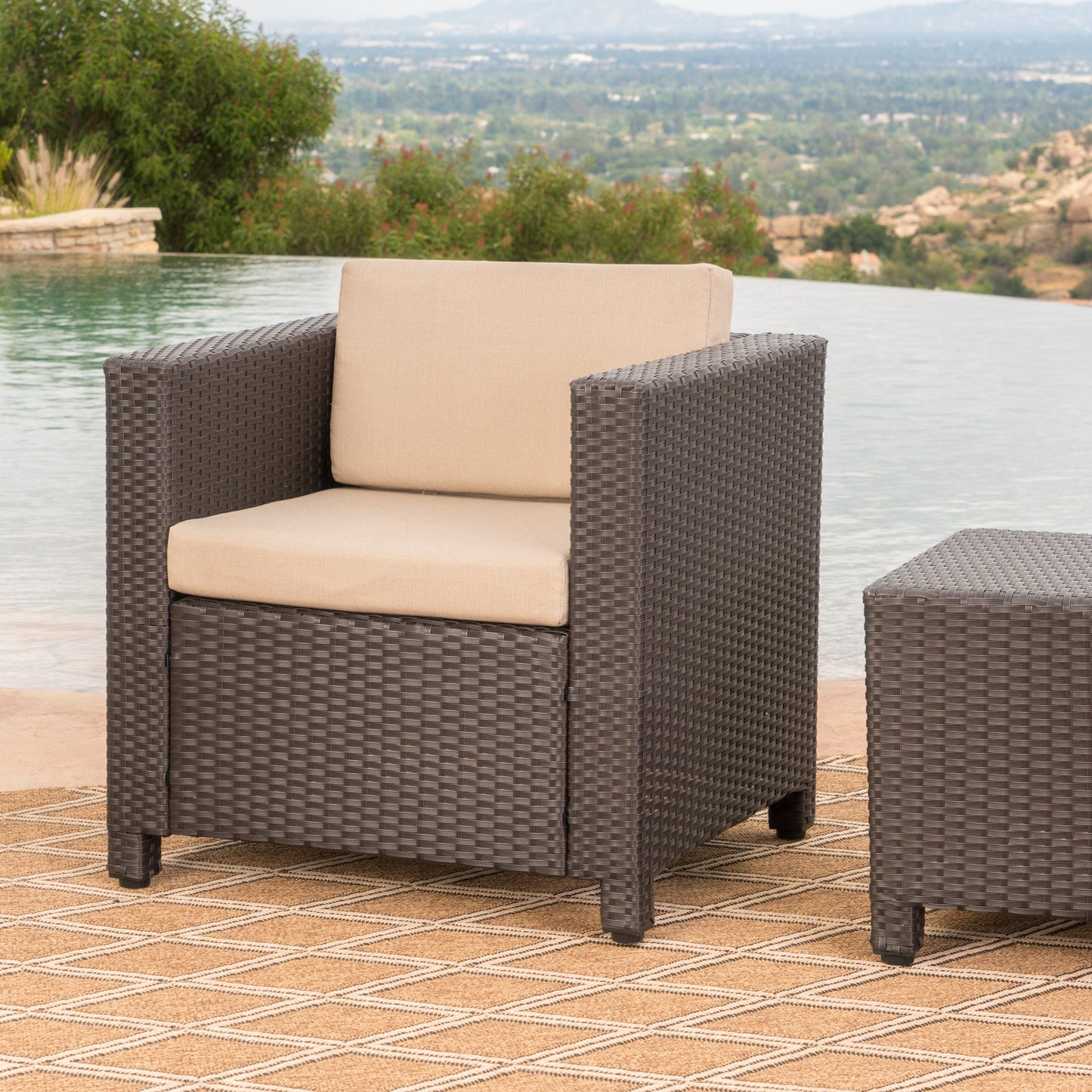 Dark brown wicker armchair with beige cushions for outdoor lounging
