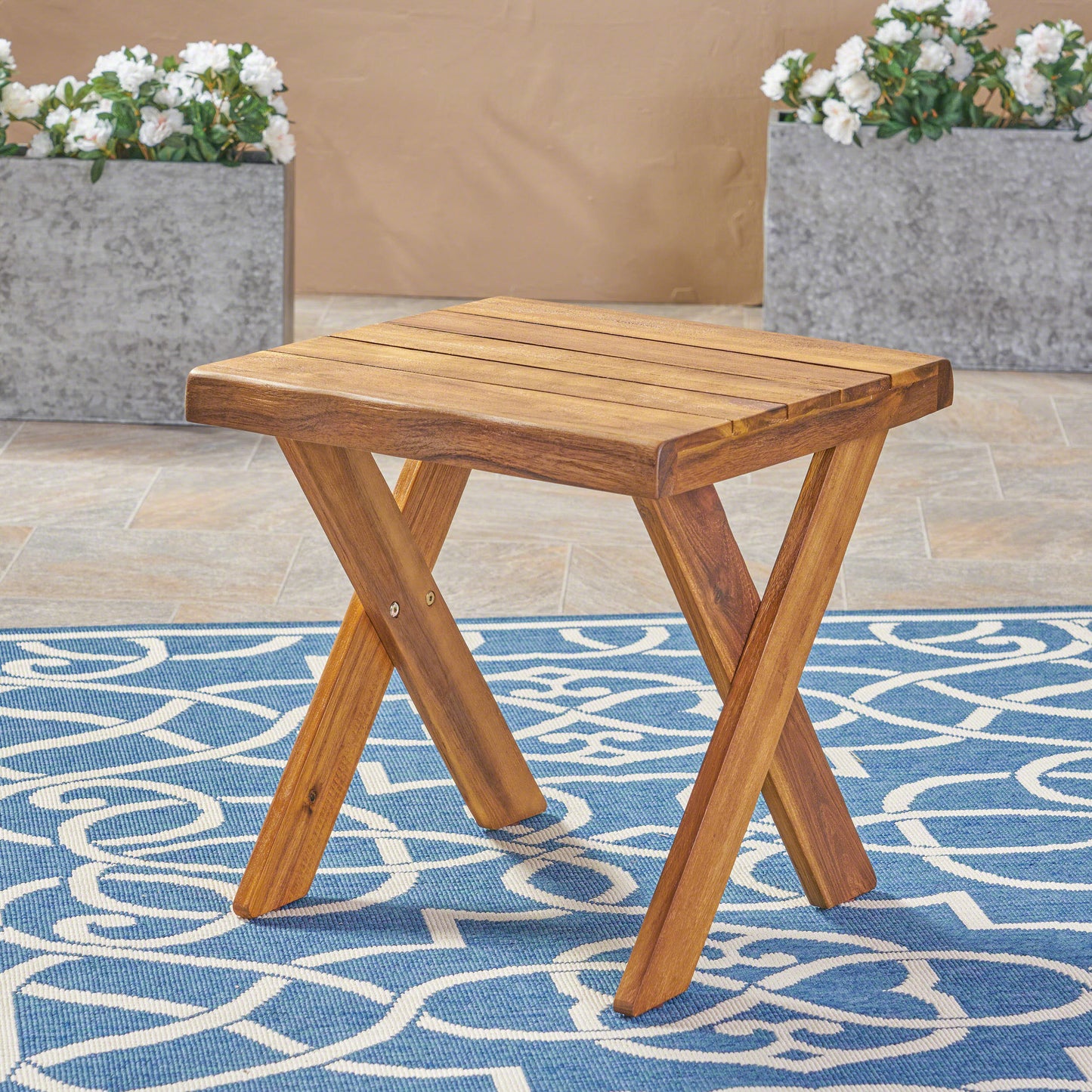 Acacia wood side table with a slatted top and Xshaped legs perfect for outdoor patios