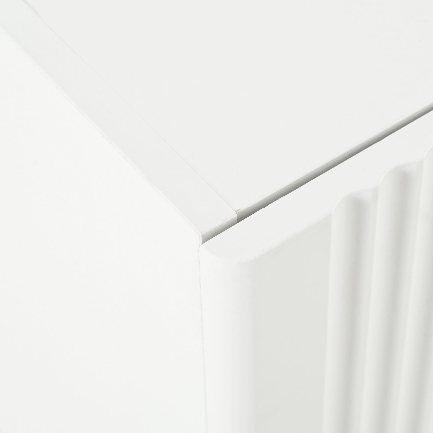 Closeup of a white cabinet with fluted detailing on its side panel
