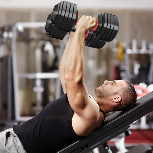 Adjustable dumbbell set with black plates and red accents used for chest press