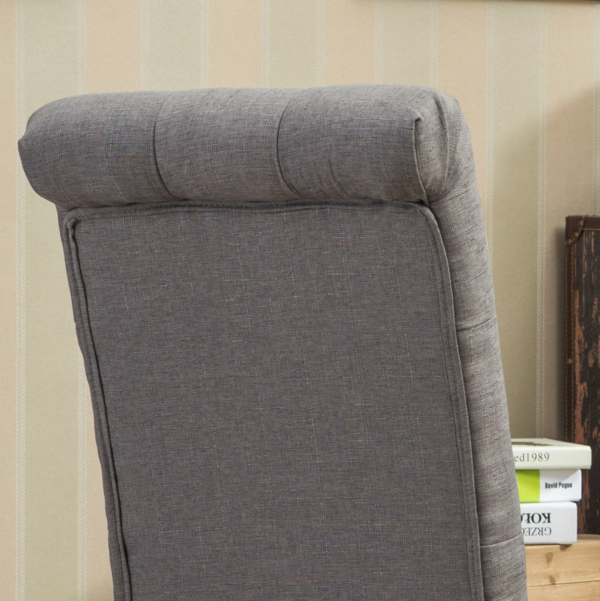 Closeup of a tufted grey fabric armchair back with subtle stitching details