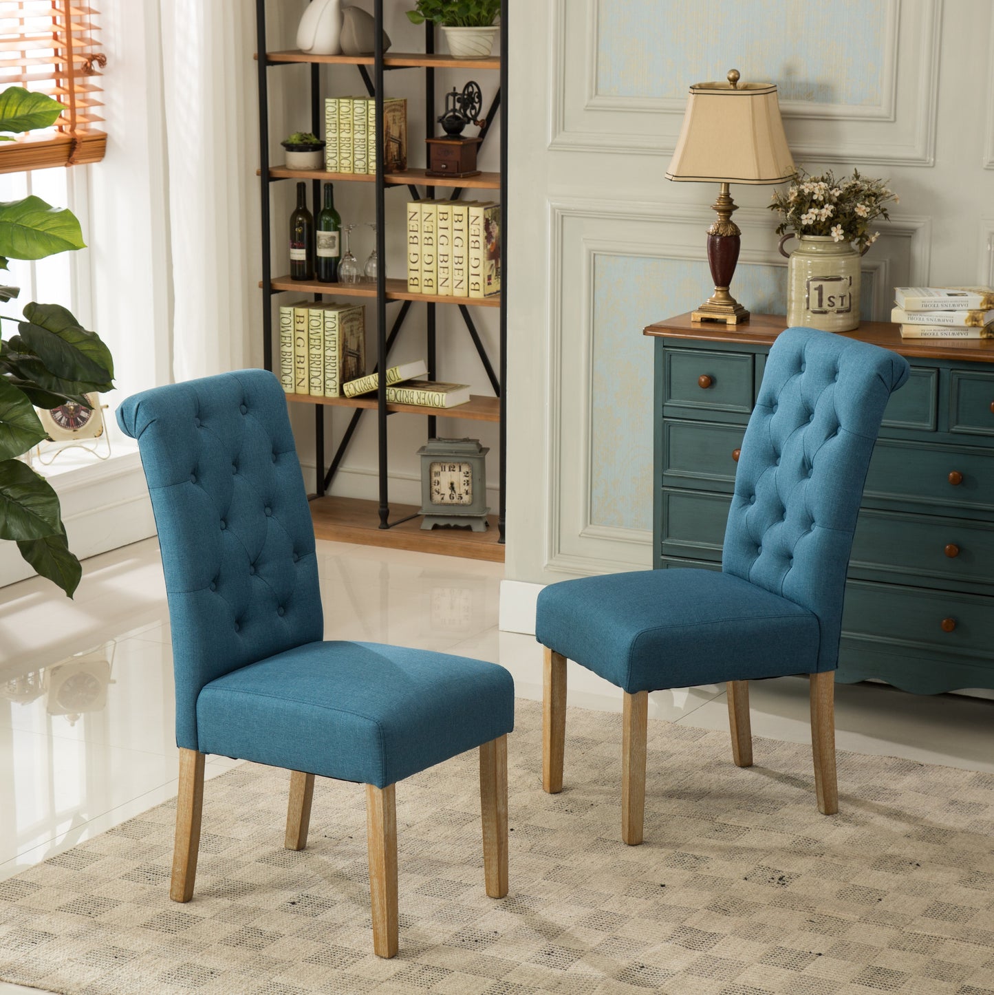 Two blue upholstered dining chairs with tufted backs and light wood legs