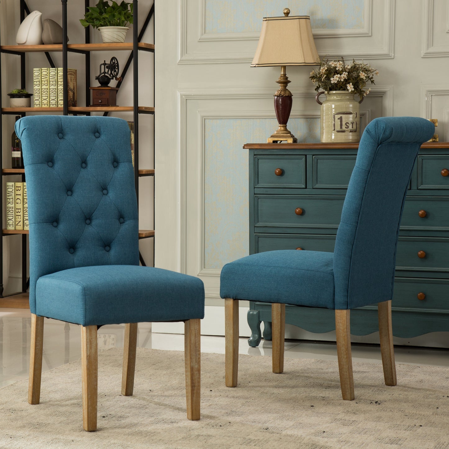 Two tufted blue fabric dining chairs with wooden legs and diamond button accents
