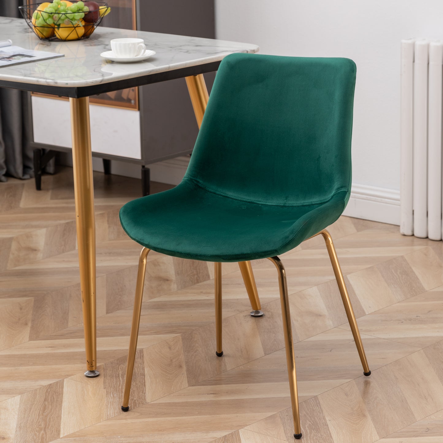 Emerald green velvet dining chair with sleek gold legs