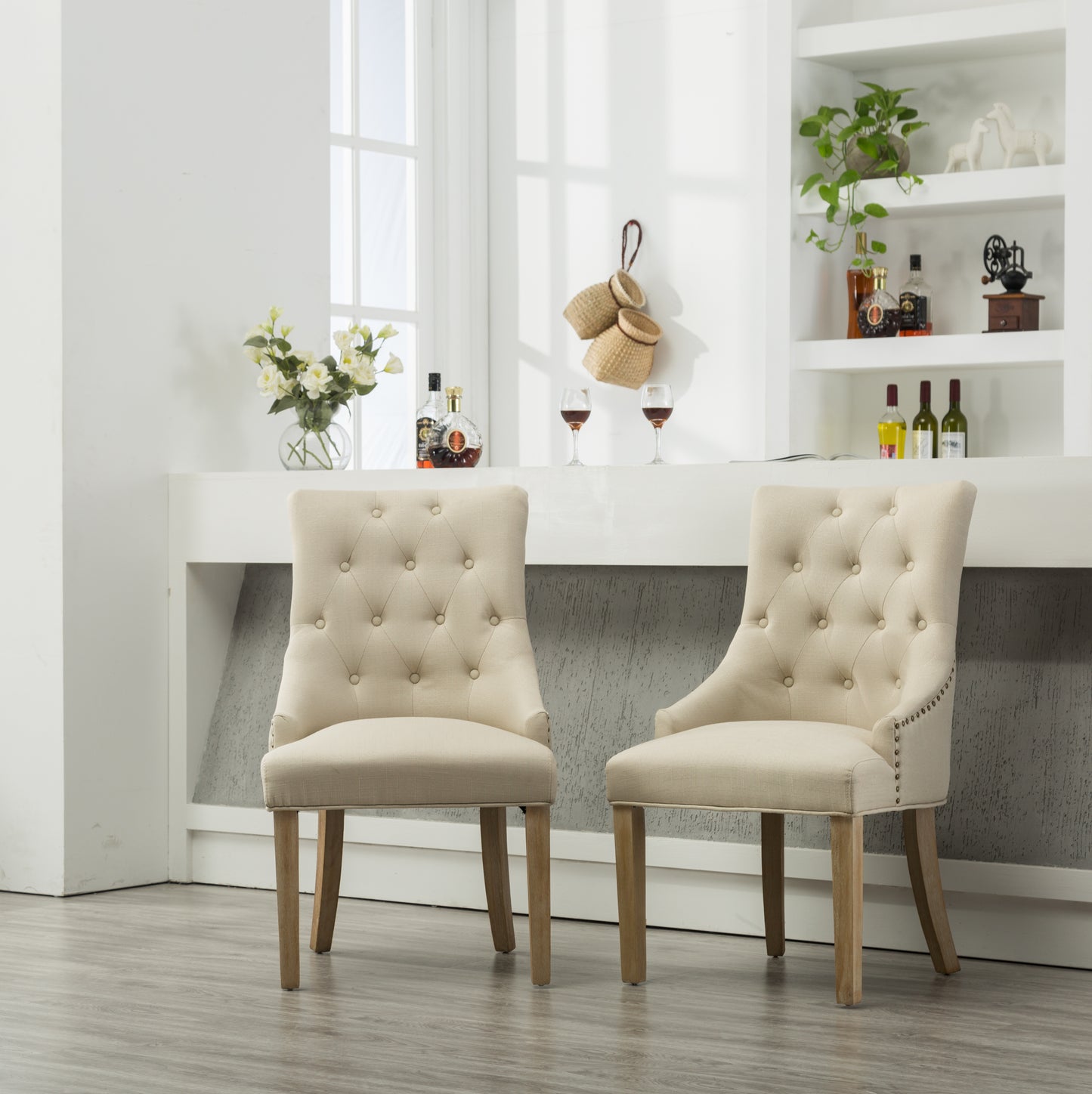 Tufted beige linen dining chair with nailhead trim and natural wood legs