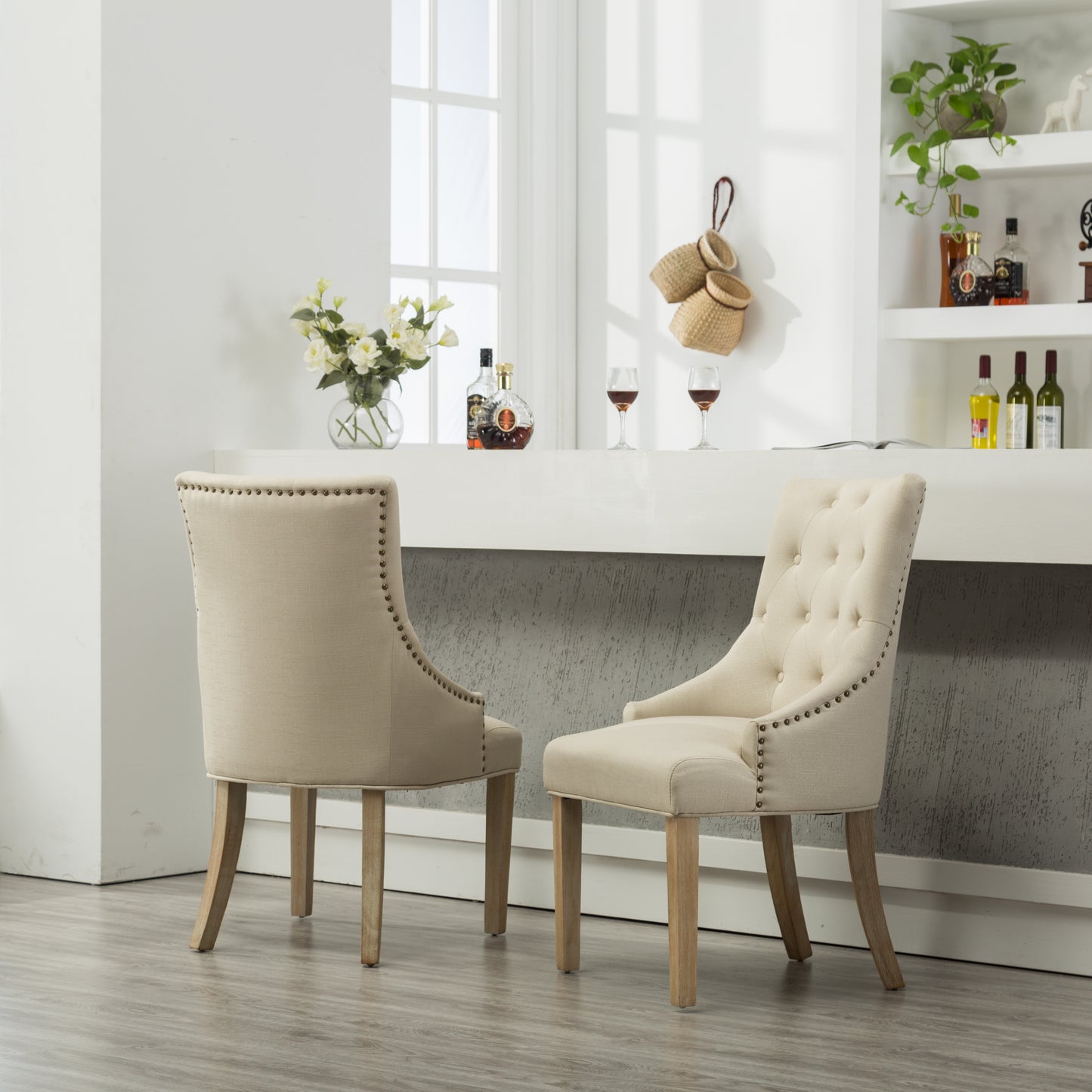 Tufted back accent chair in beige linen with nailhead trim and oak legs