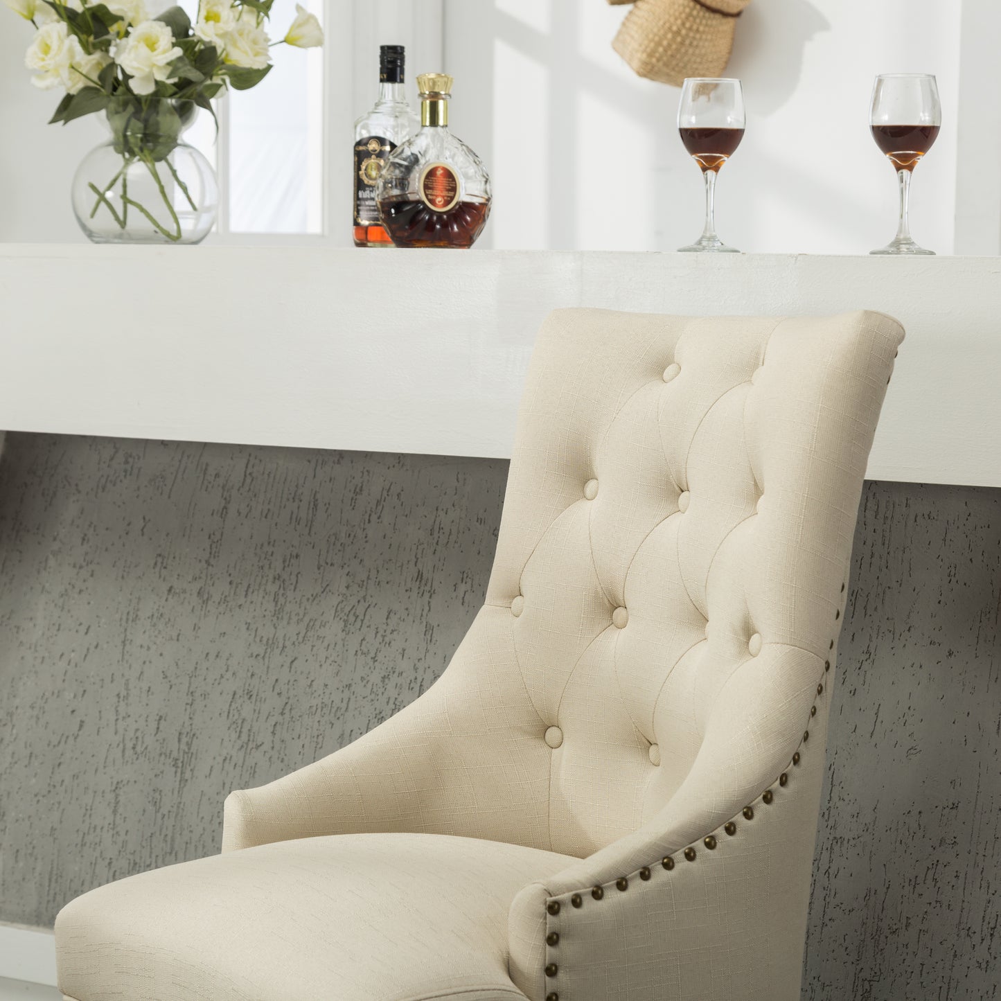 Cream fabric accent chair with diamond tufting and antique brass nailhead trim