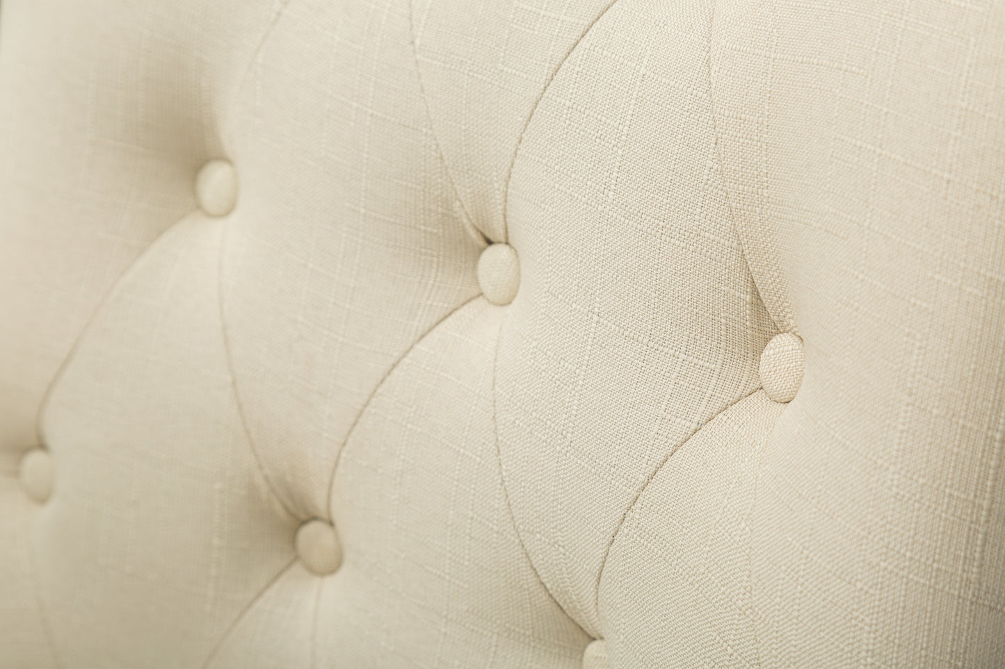 Close up of cream linen fabric tufted with buttons ideal for upholstery