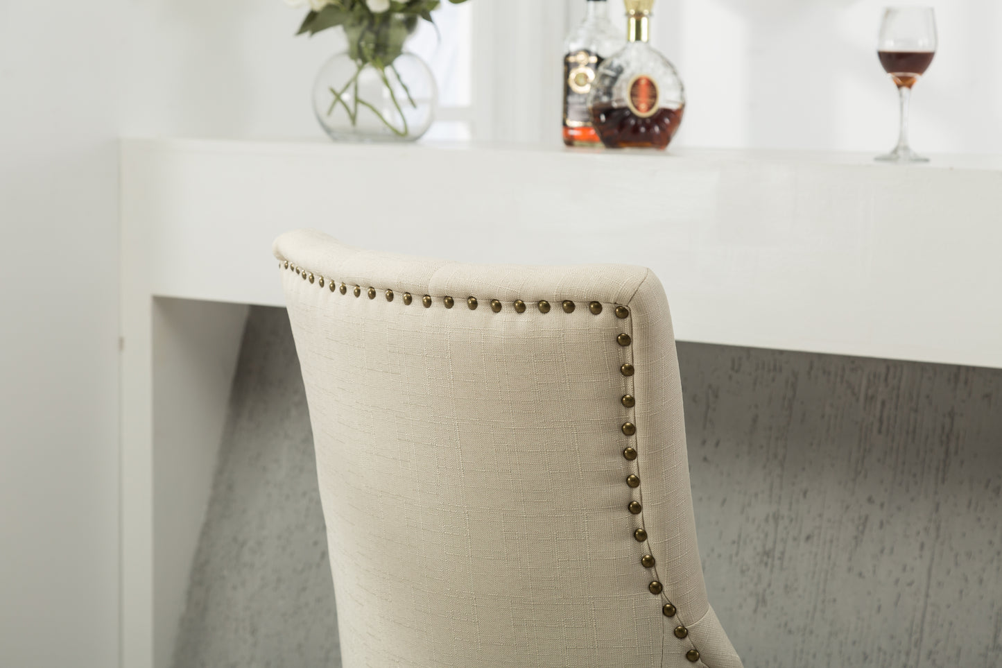Upholstered dining chair in natural linen with antique brass nailhead trim
