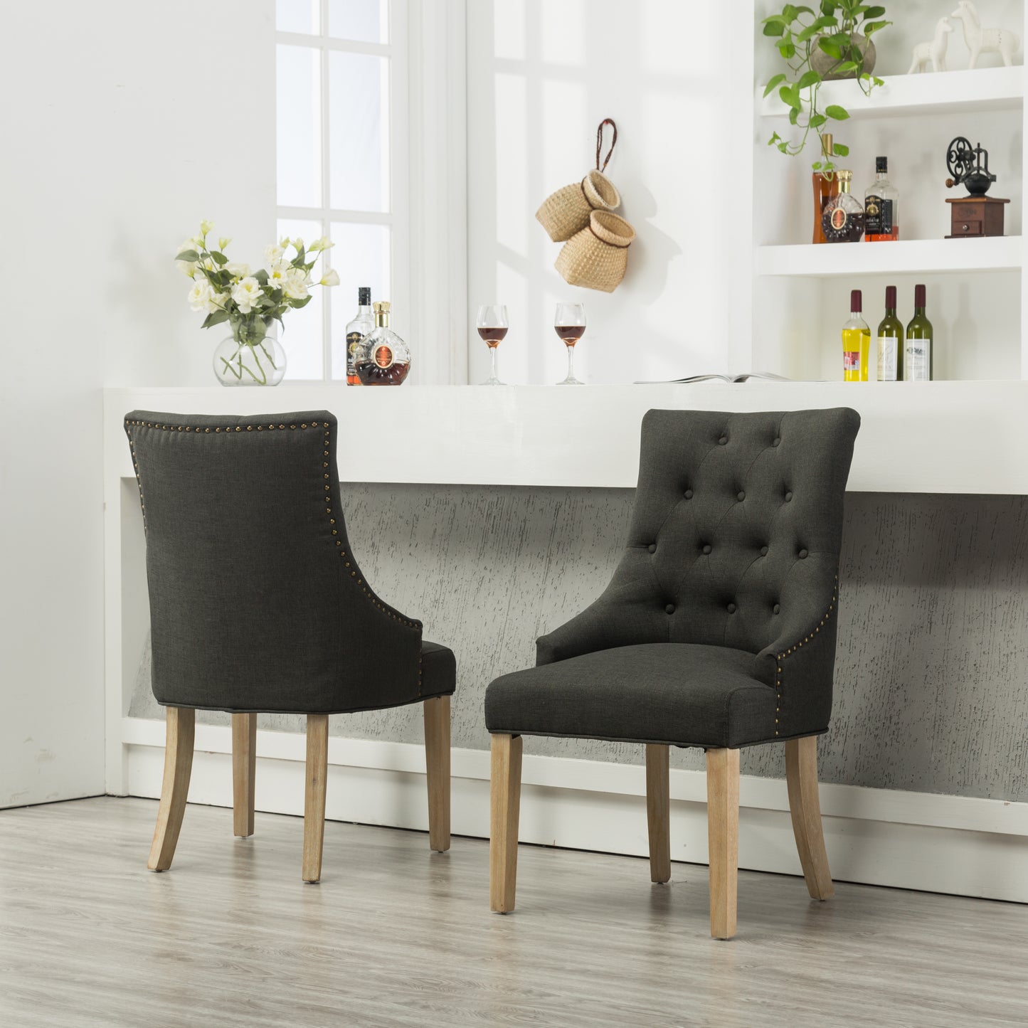 Dark gray linen upholstered dining chair with brass nailhead trim and tufted back