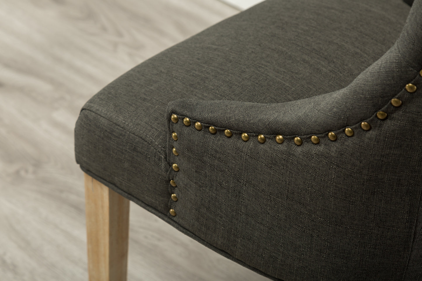 Dark gray linen accent chair with brass nailhead trim and wooden leg