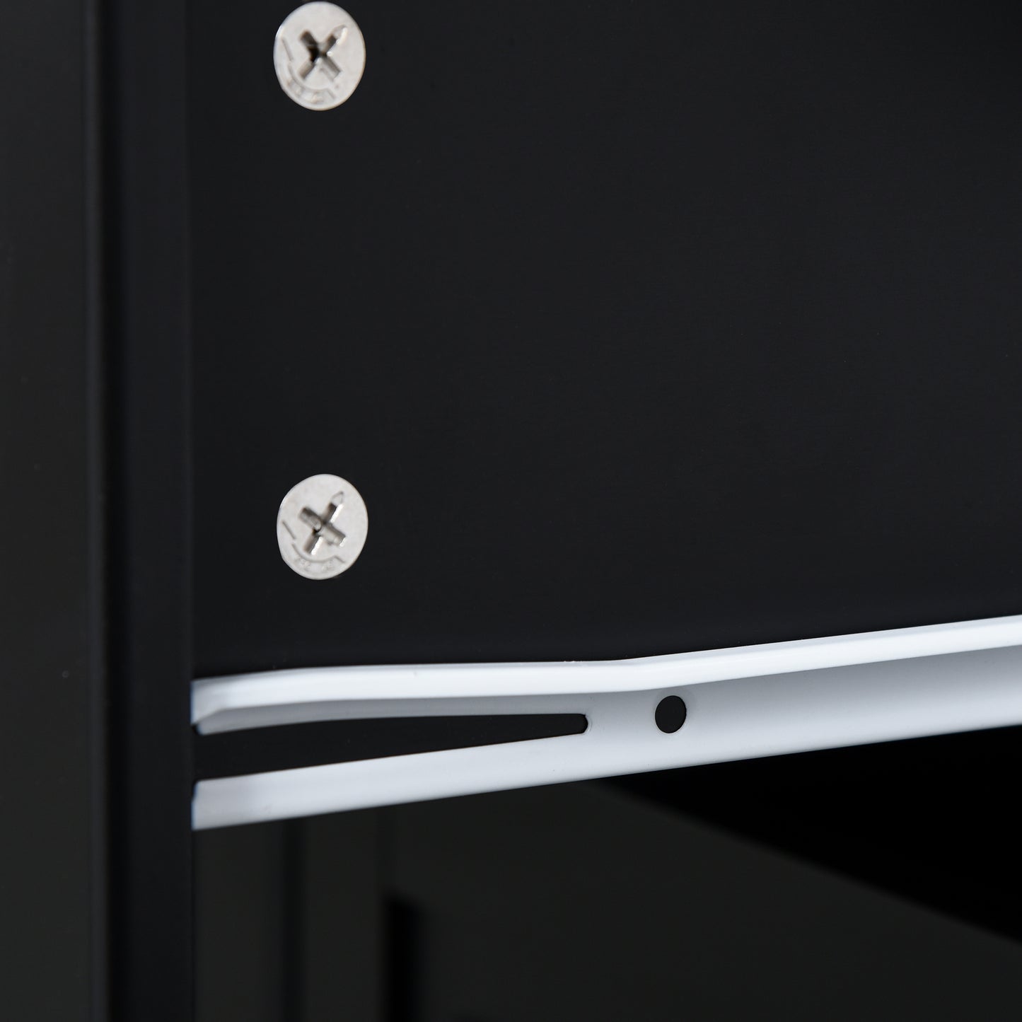 Closeup of two silver screws on a black metal surface