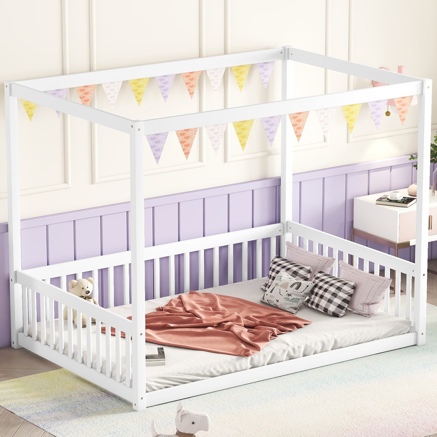 White wooden canopy bed with colorful heart bunting for kids