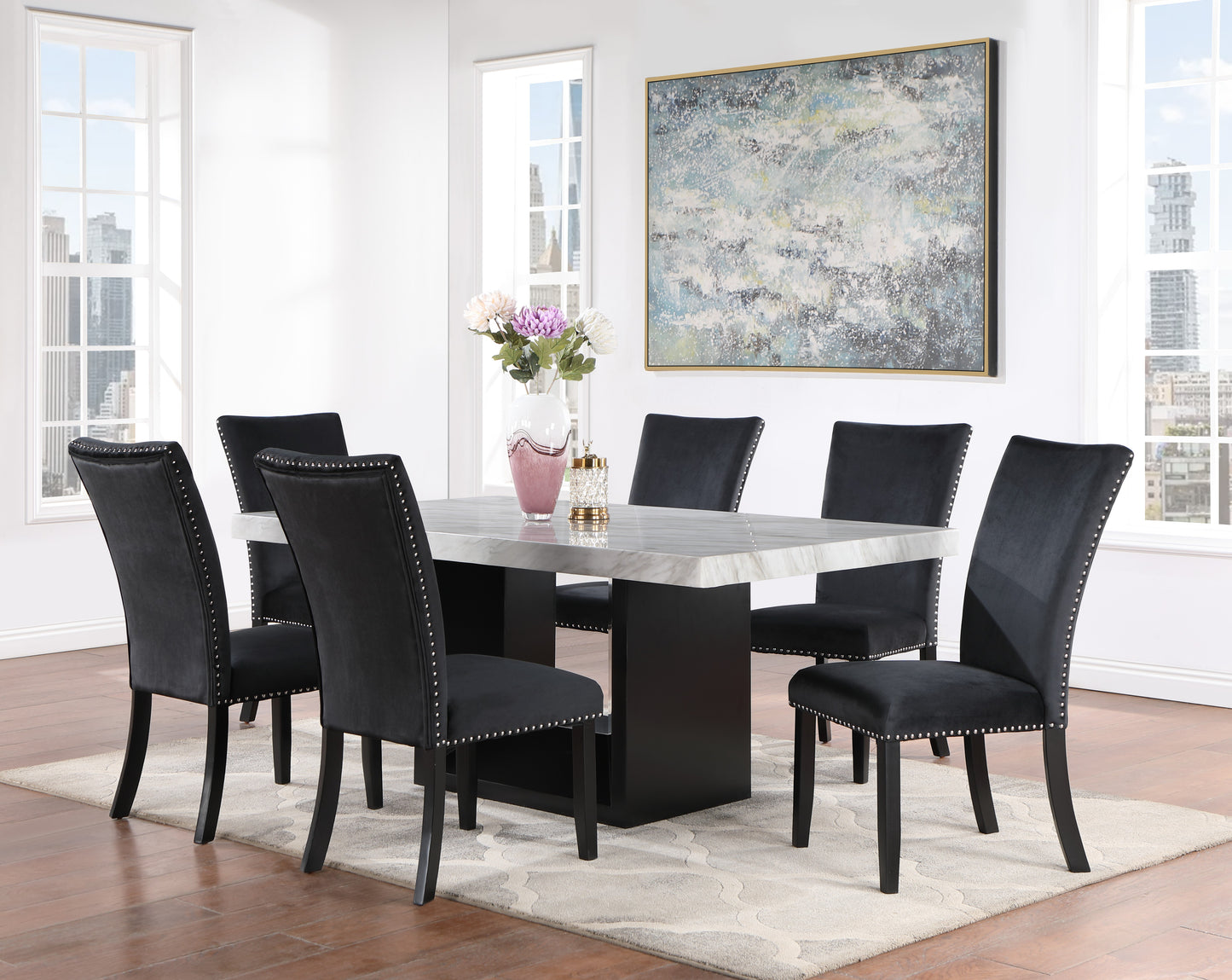 Black velvet dining chairs with nailhead trim surrounding a marbletop table