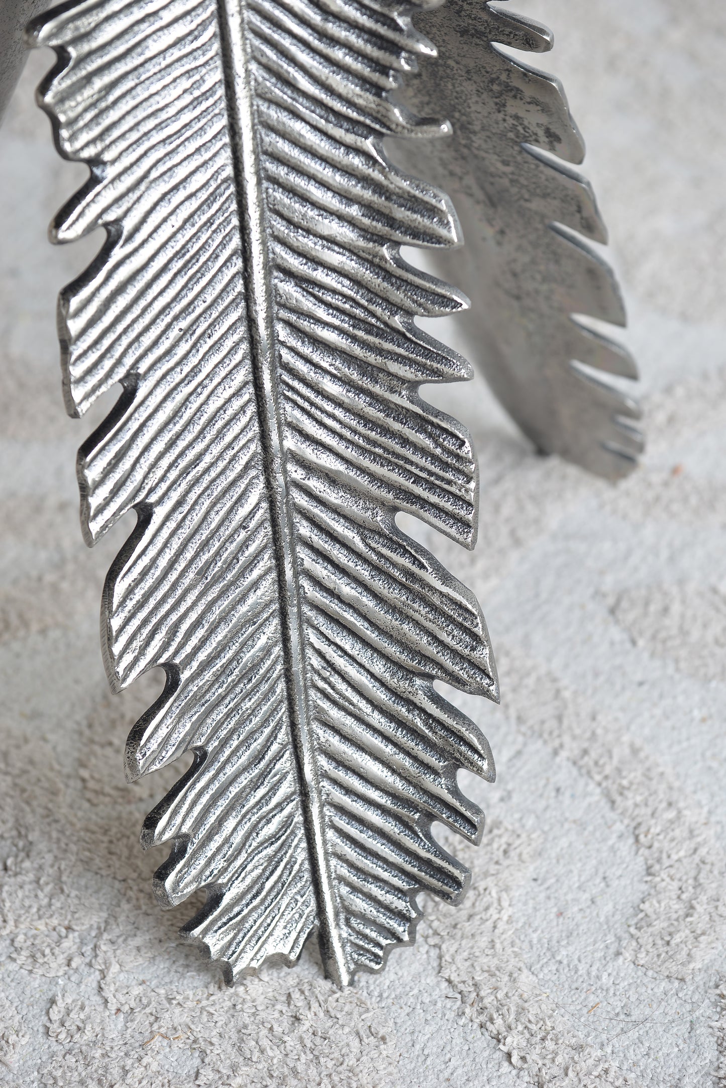 Silver metal feather cuff bracelet with textured detail