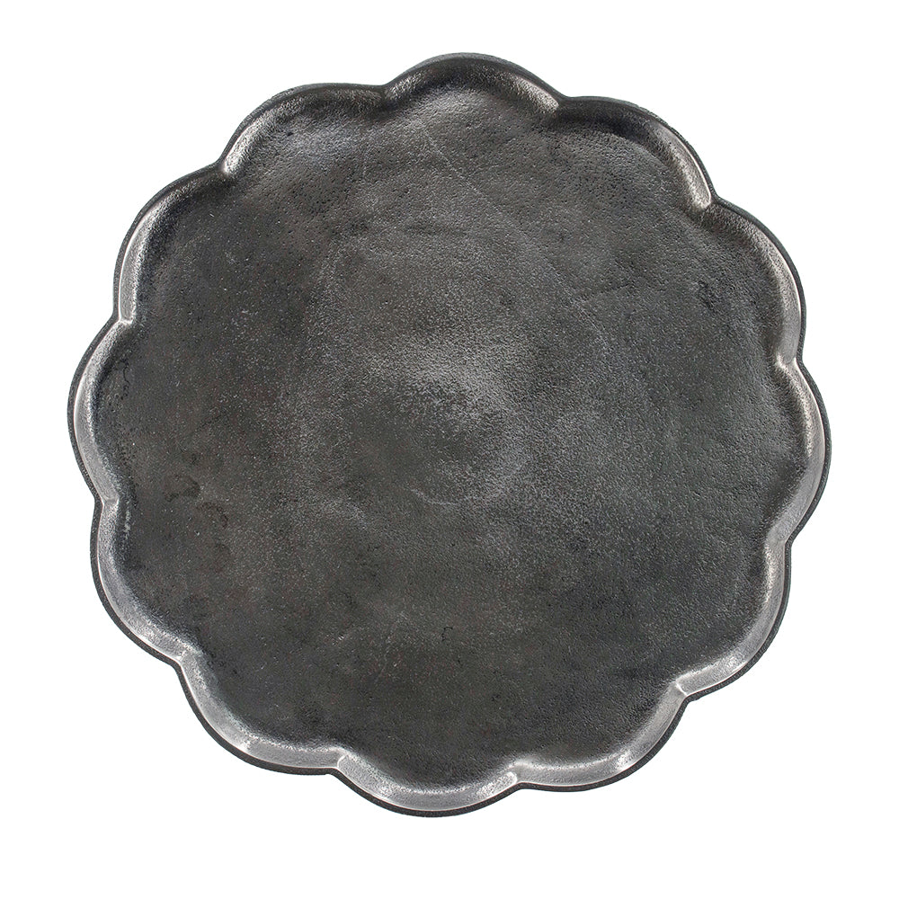 Rustic cast iron round scalloped serving tray with a textured matte finish for kitchen use
