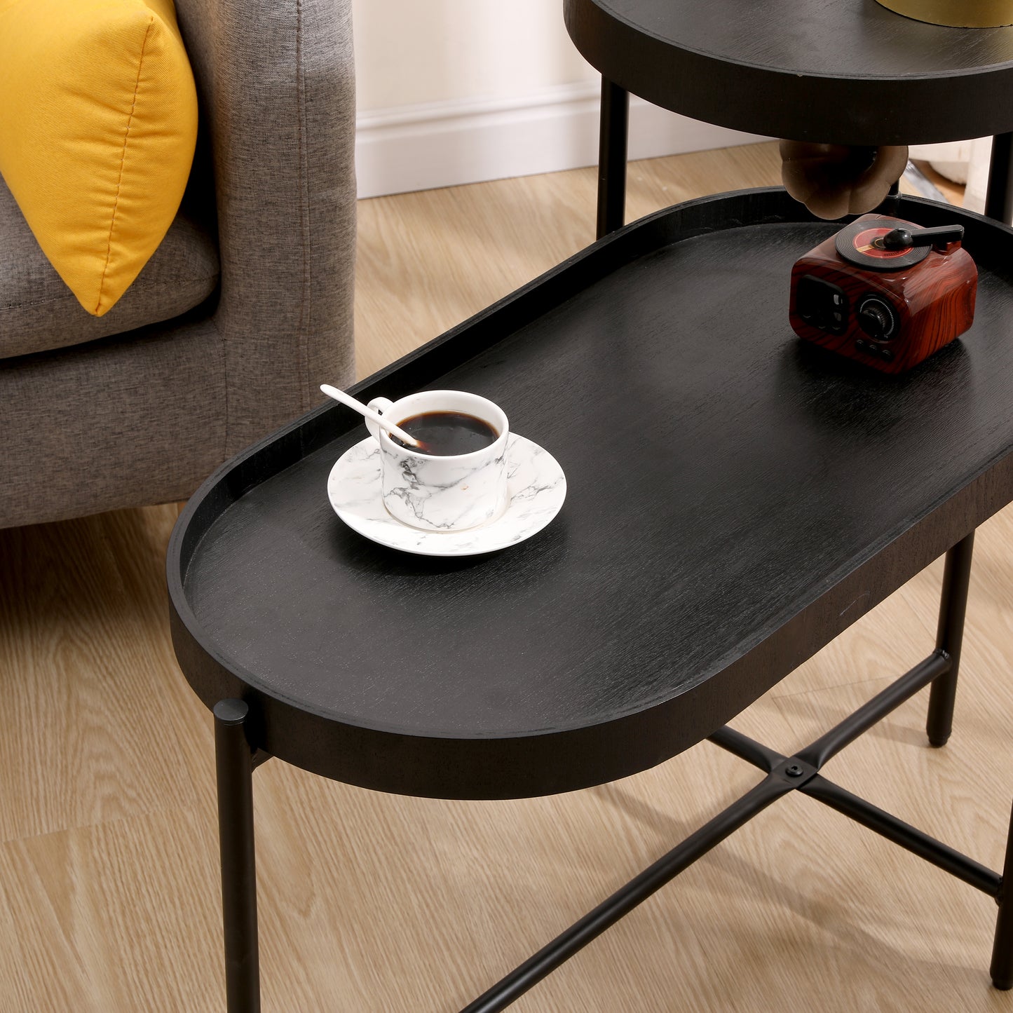 Black oval tray coffee table with wooden texture and metal legs