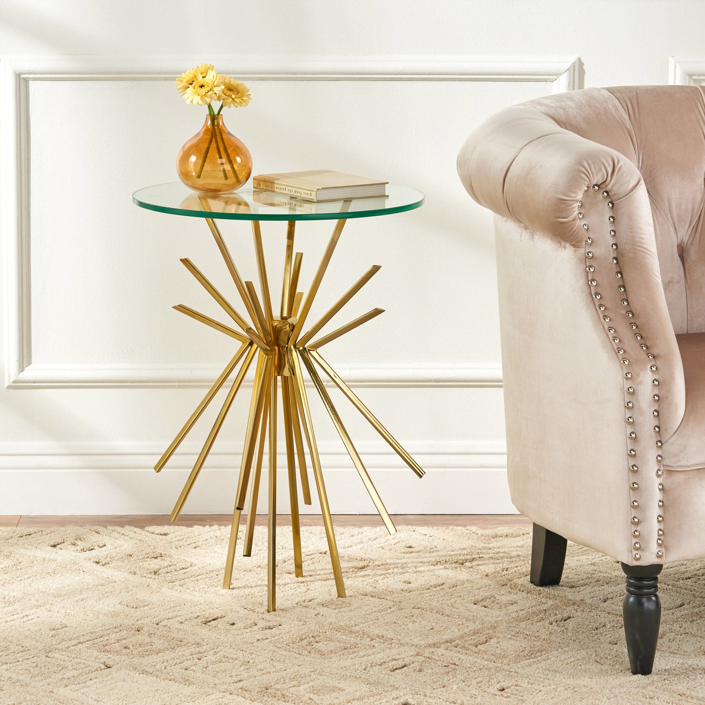 Sleek gold metal side table with a round glass top and starburst base Perfect accent for modern living rooms