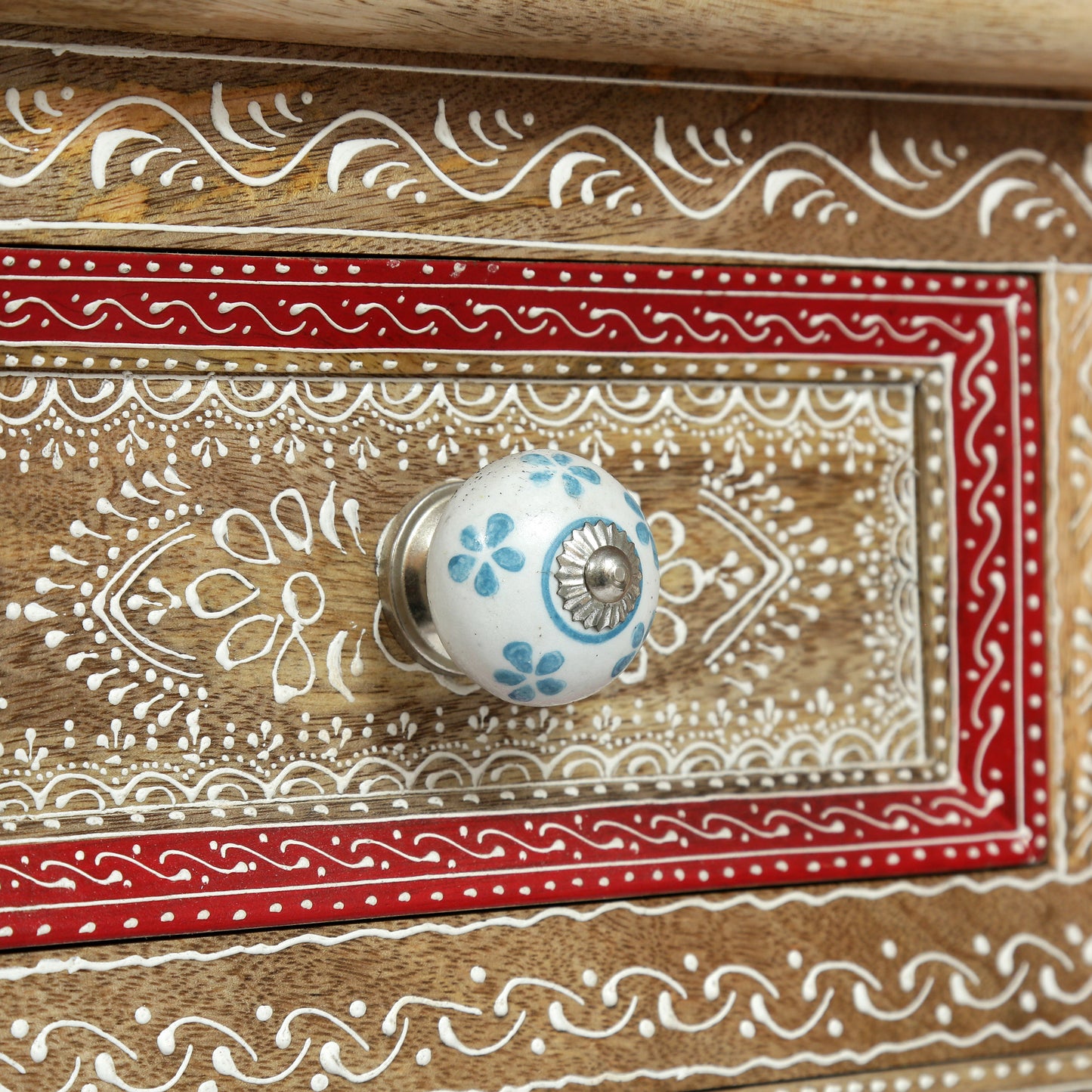 Wooden drawer knob with blue floral pattern on a handpainted chest of drawers