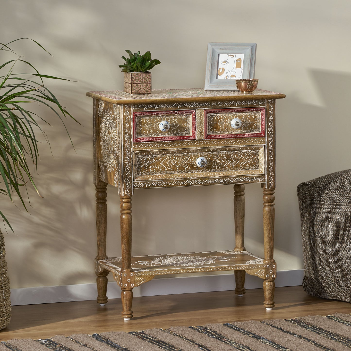 Wooden accent cabinet with three drawers and intricate white detailing