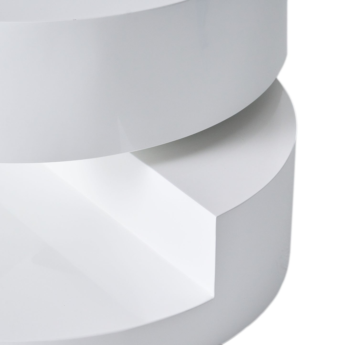 Closeup of a glossy white modernist side table showcasing its curved edges and layered design