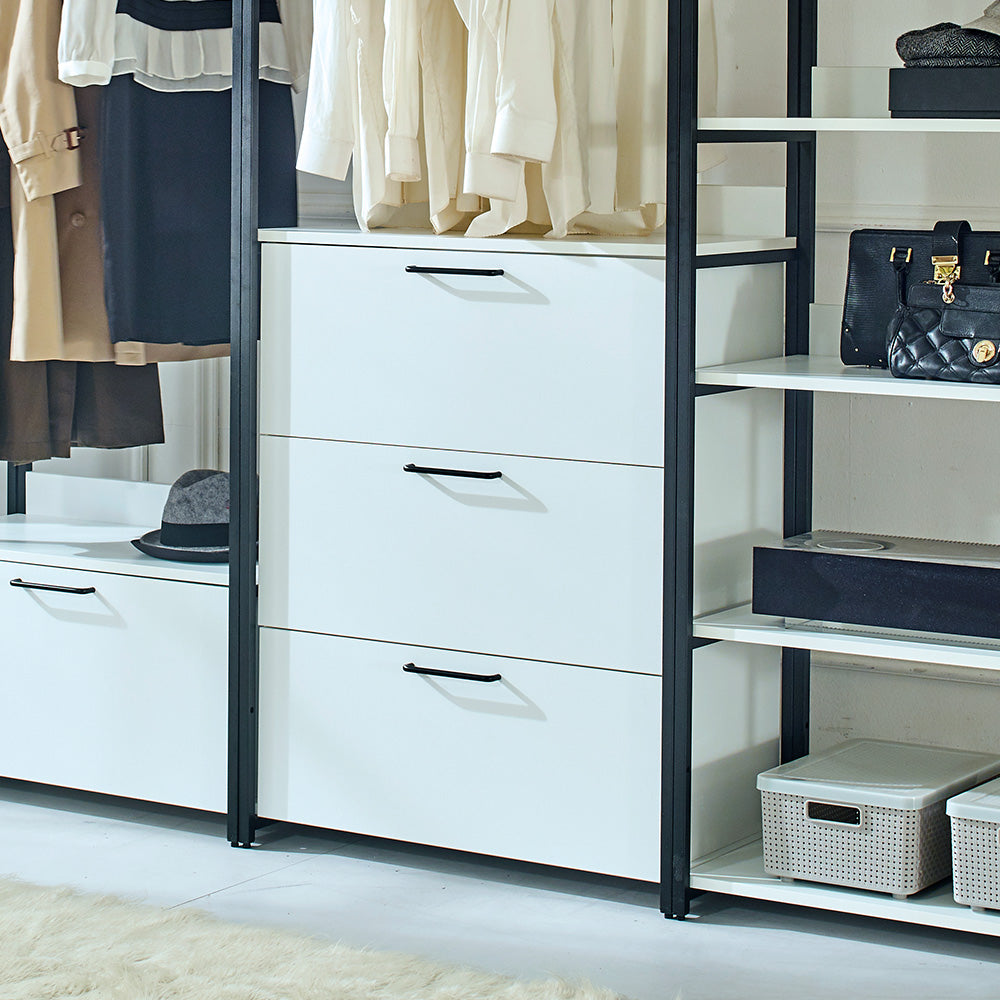 White chest of drawers with black handles in a modern closet