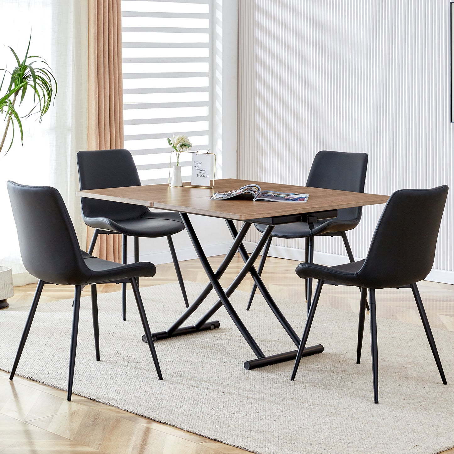 Modern black faux leather dining chairs with sleek metal legs set around a walnut wood dining table