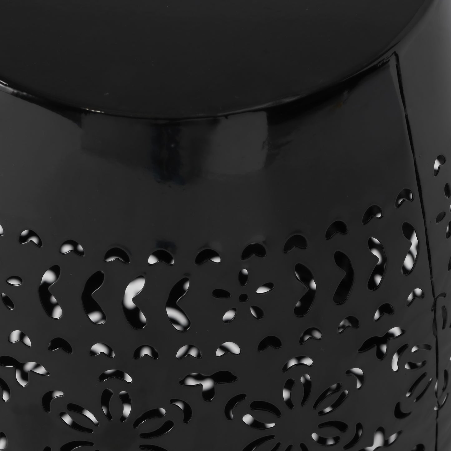 Black metal outdoor stool with ornate floral cutouts for garden decor