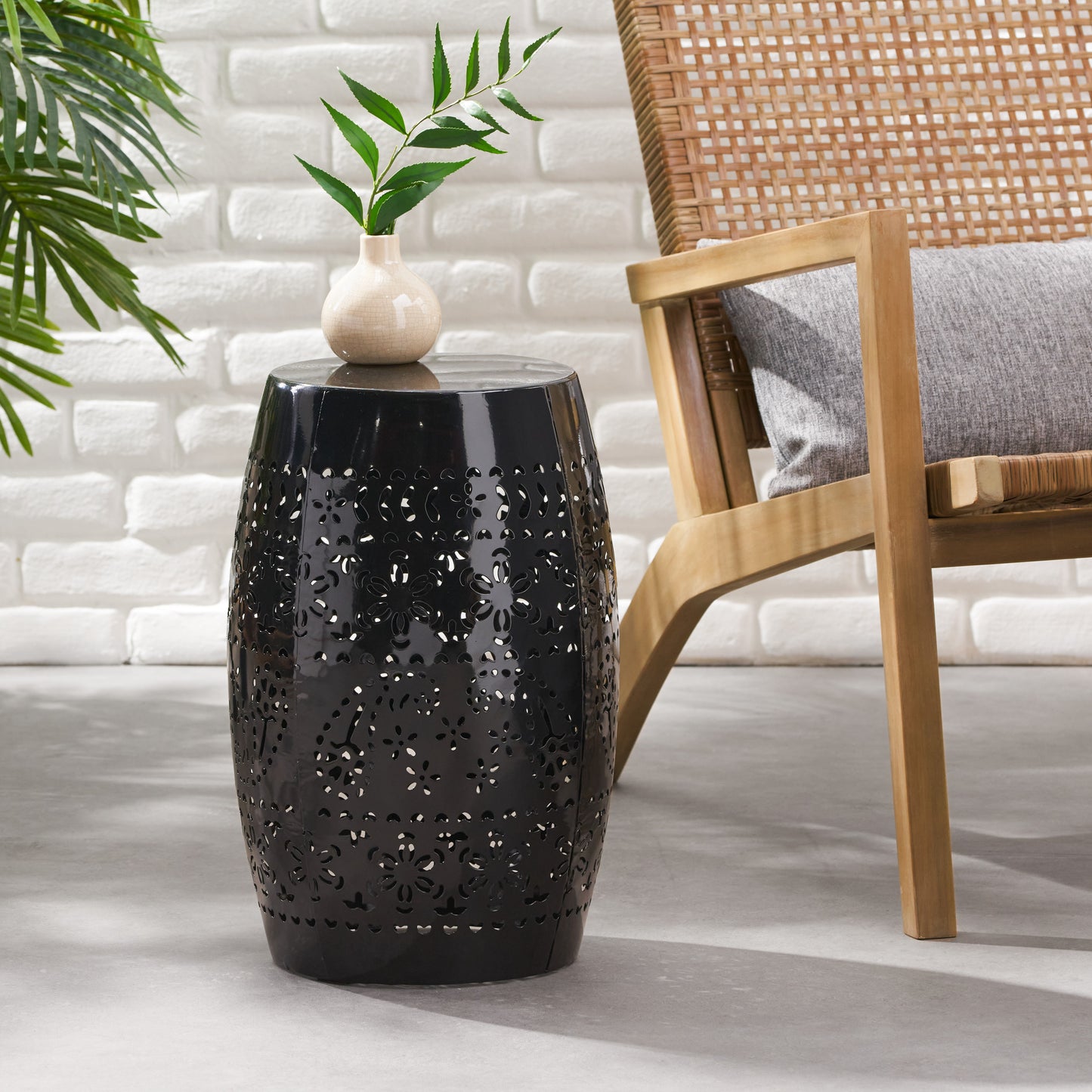 Black metal garden stool with intricate floral cutouts perfect for outdoor seating