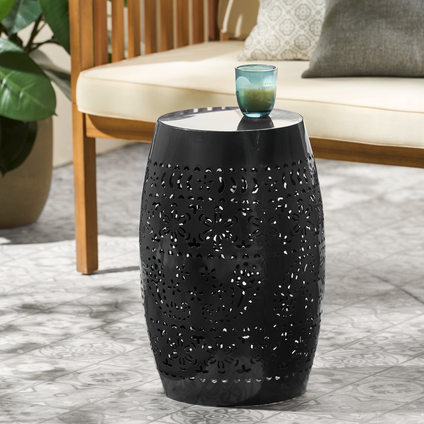 Black metal garden stool with floral cutouts perfect for outdoor seating