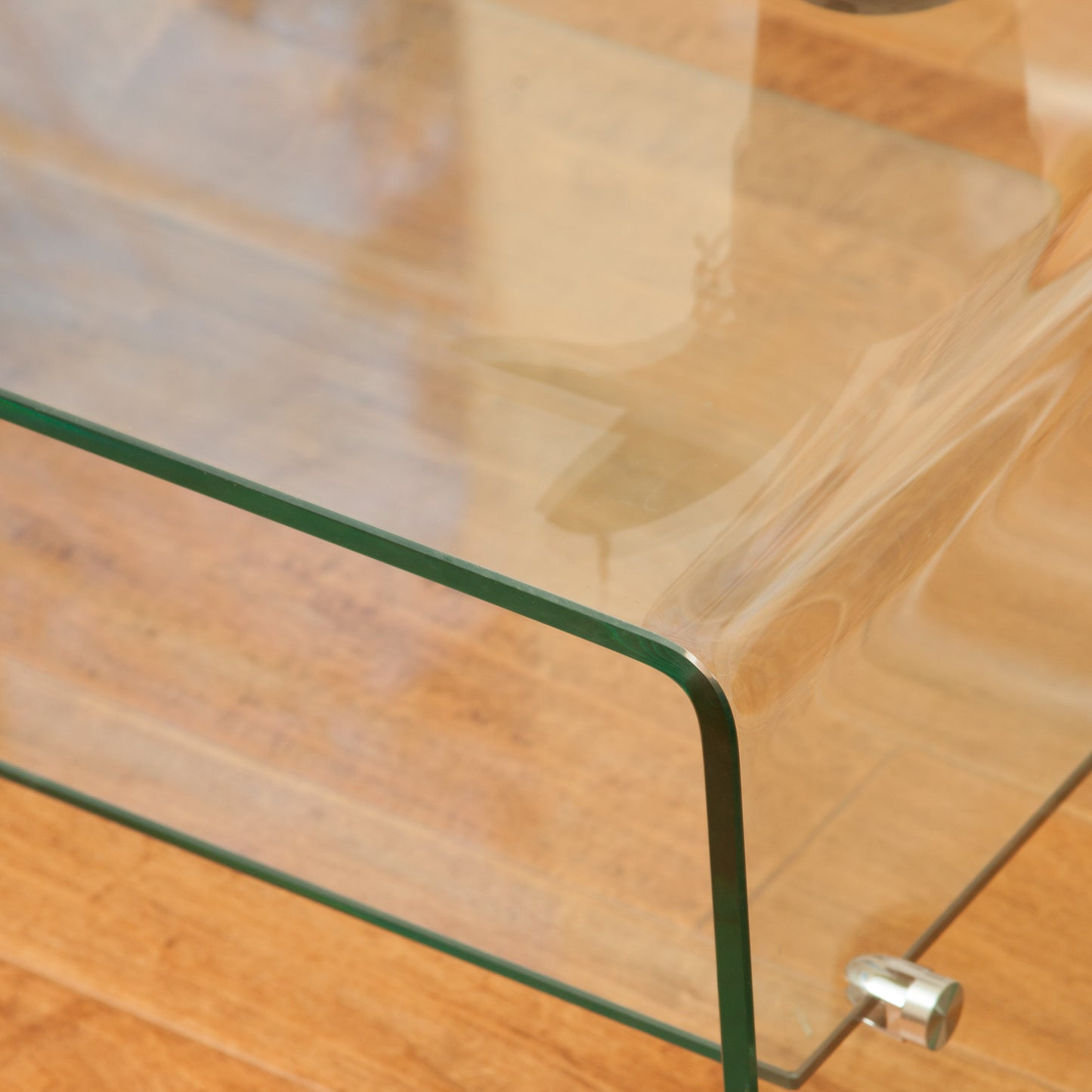 Clear tempered glass coffee table with rounded edges and silver feet