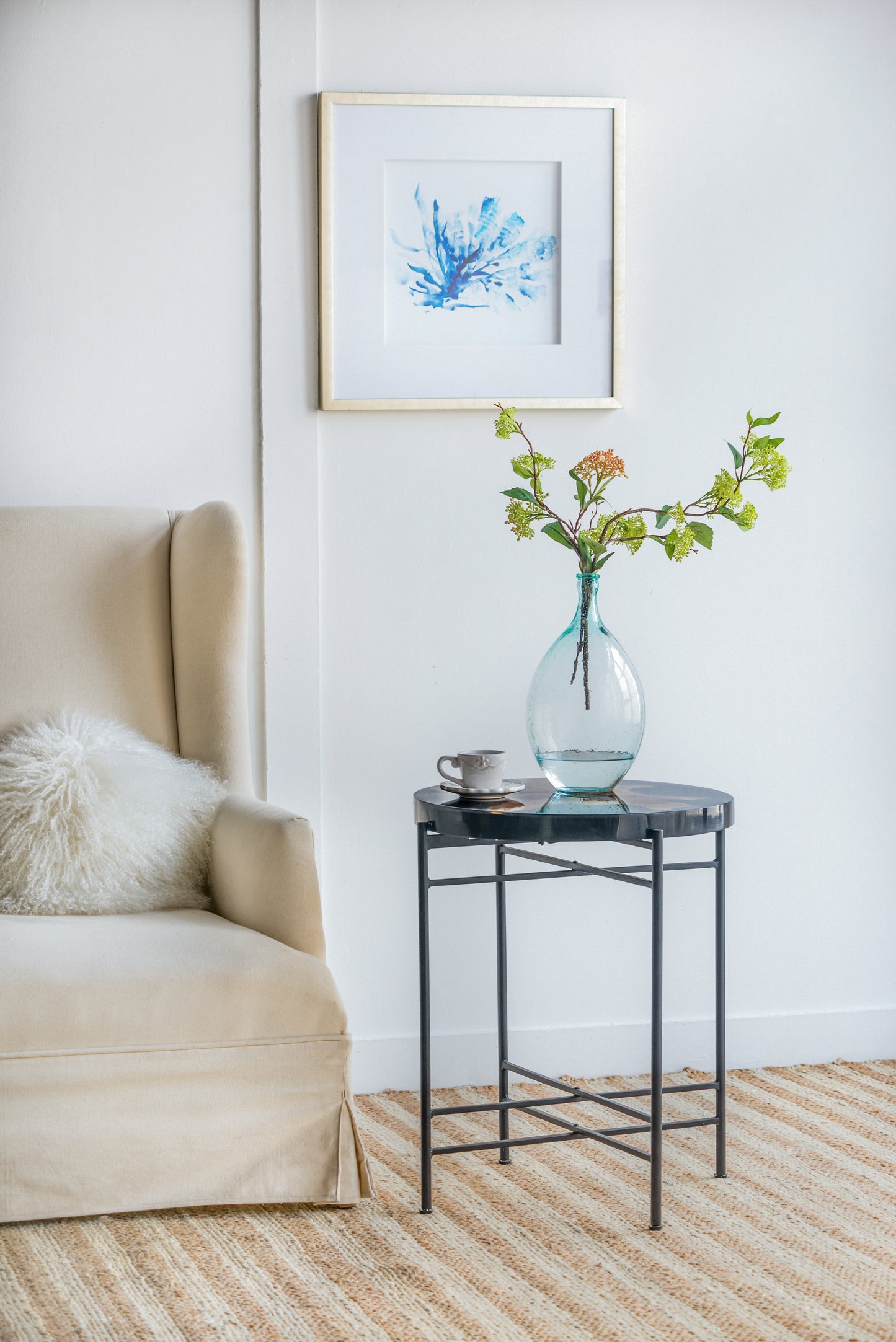 Framed abstract watercolor of blue coral on white background in a gold metal frame