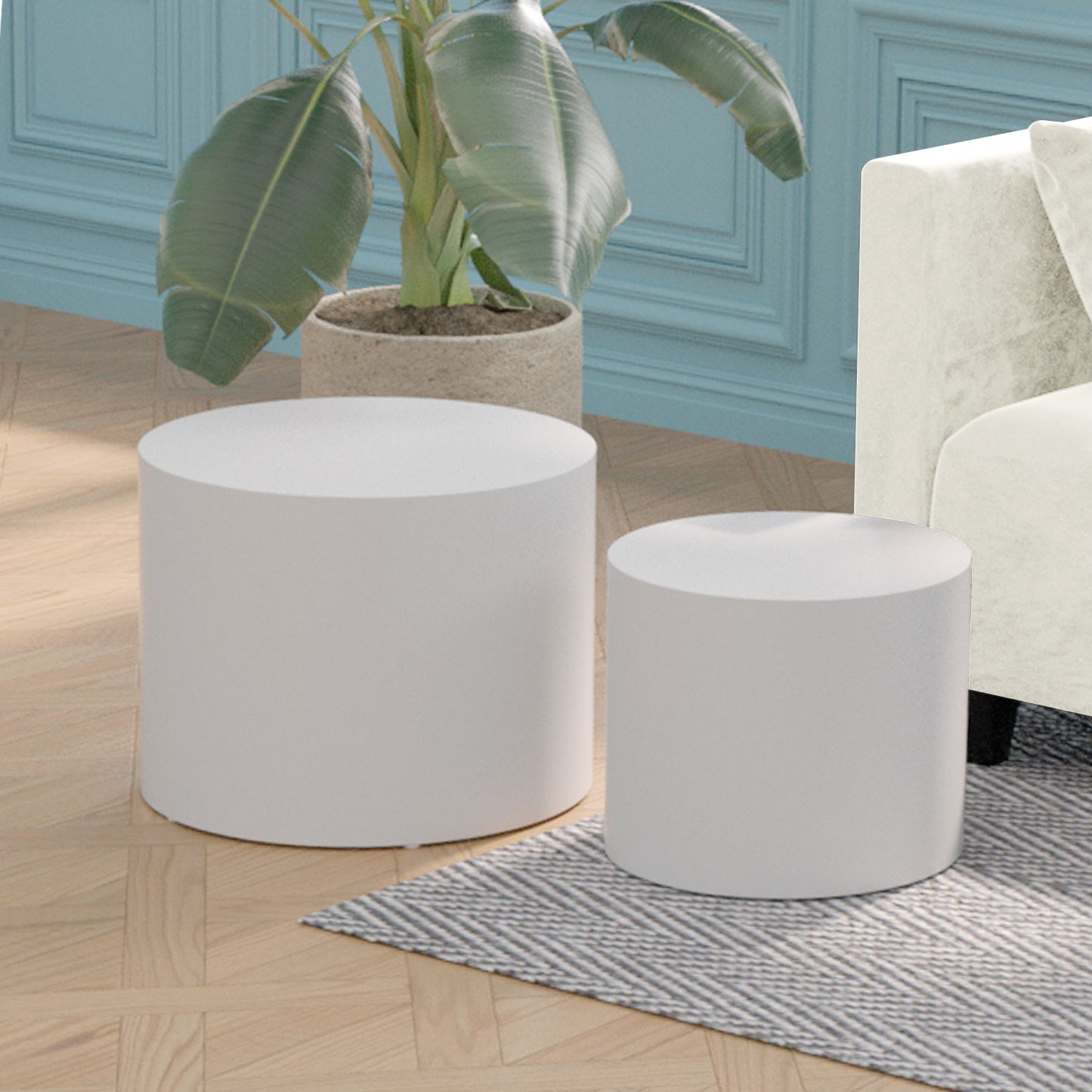 Two white cylinder ottomans on a herringbone rug and wood floor