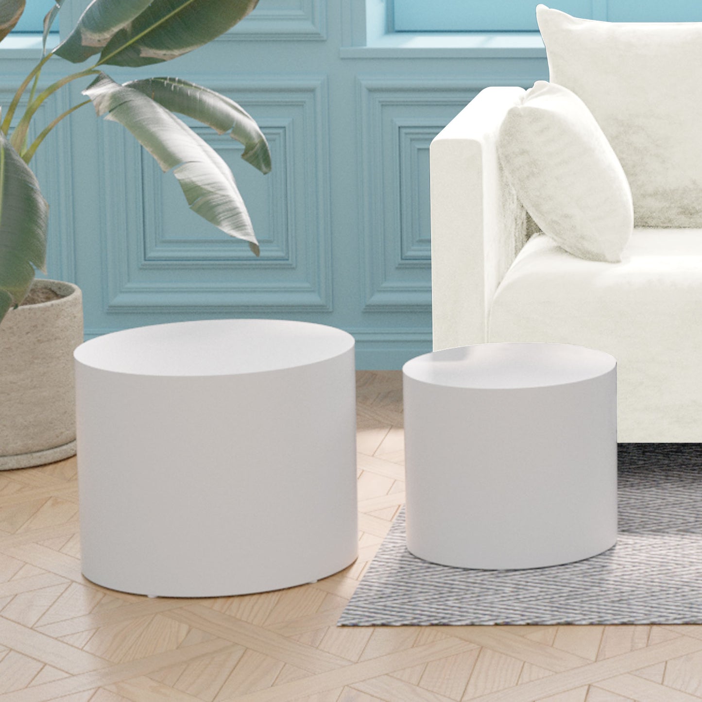 Two white cylindrical ottomans one tall and one short on a wooden floor