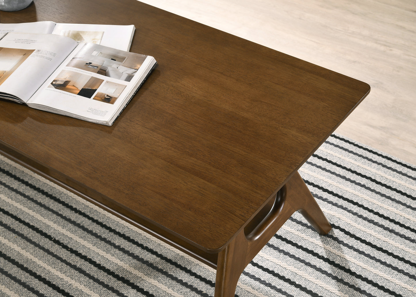 Dark wood coffee table with open magazine featuring midcentury modern design