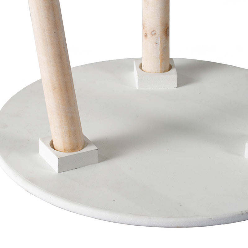 Closeup of white round tabletop with two natural wood legs angled outwards