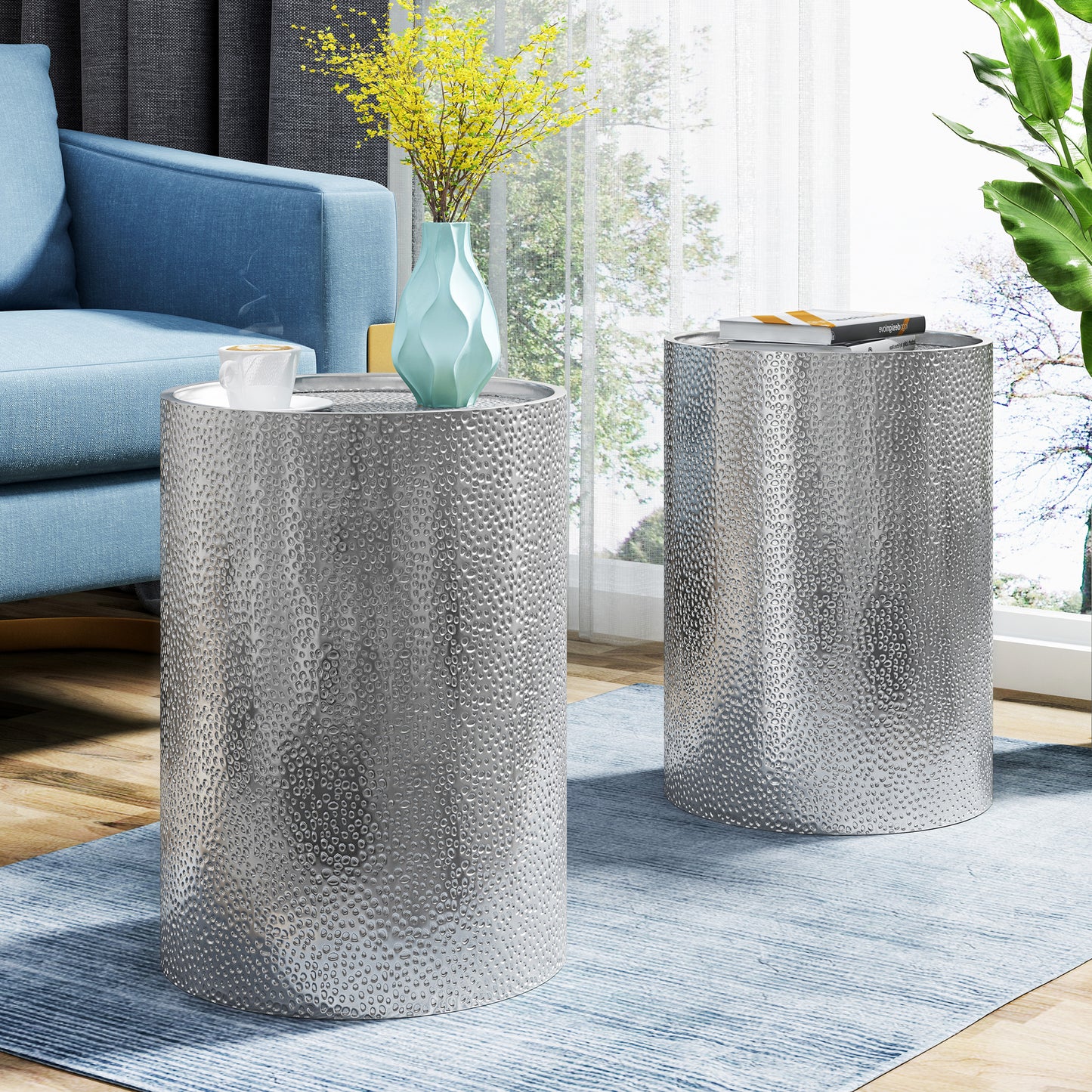 Silver hammered metal round accent table with a textured surface