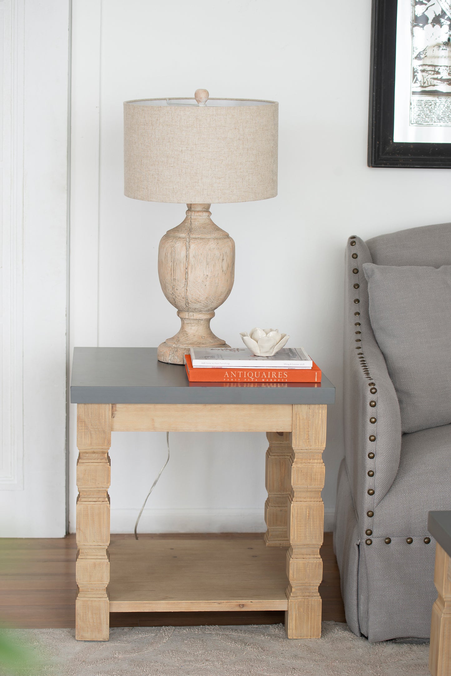 Rustic wooden table lamp with beige linen shade on a greytopped side table