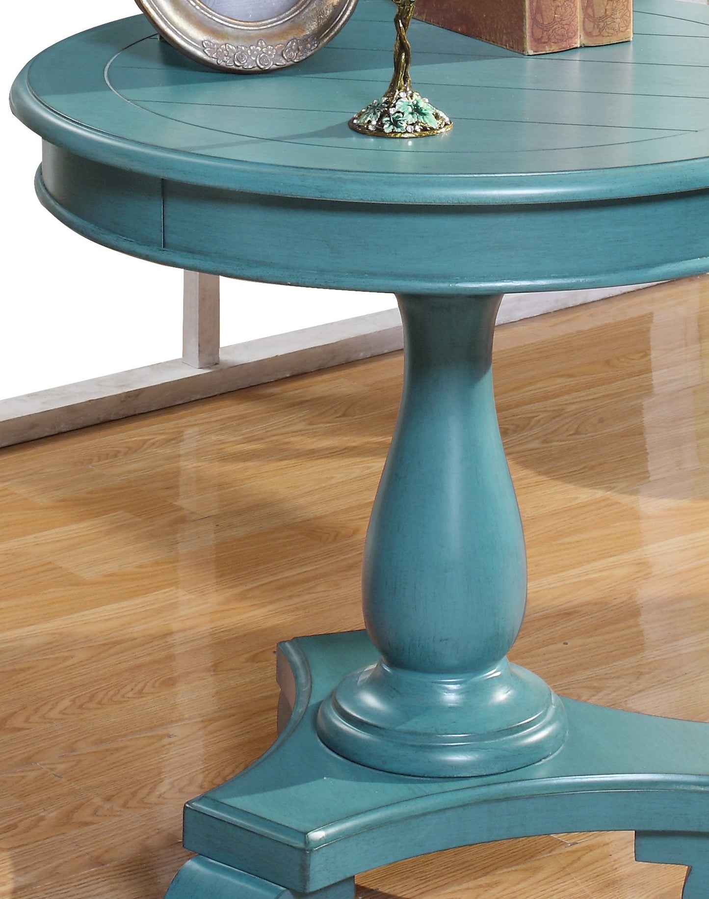 Round teal wood accent table with pedestal base and decorative base